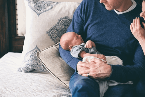 Two new parents holding their newborn.