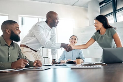 A diverse group of employees greeting each other before a meeting