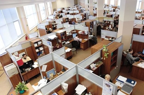 An office with many desks and employees.