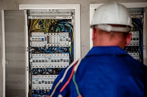 worker examining electrical wiring