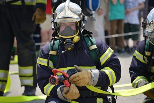 A firefighter wearing a gas mask for protection against local exhaust ventilation (LEV).