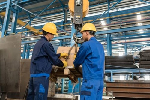 two employees attaching safety ropes to a box